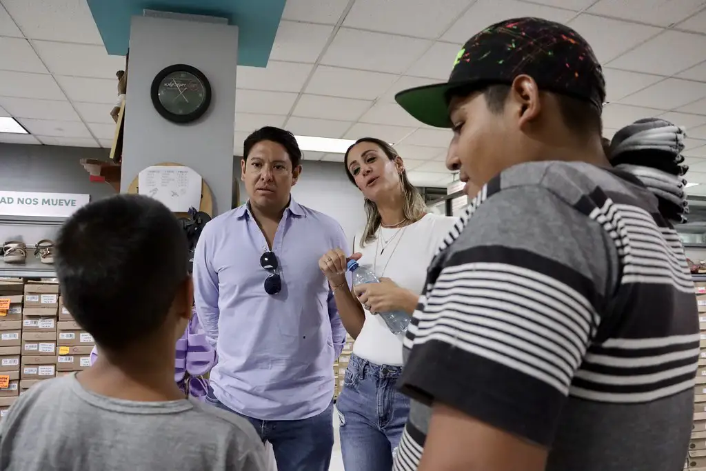 Representantes de Grupo PLA Firme dialogando con jóvenes beneficiados en Barrios Unidos durante la entrega de zapatos patrocinada por Santa Julia.