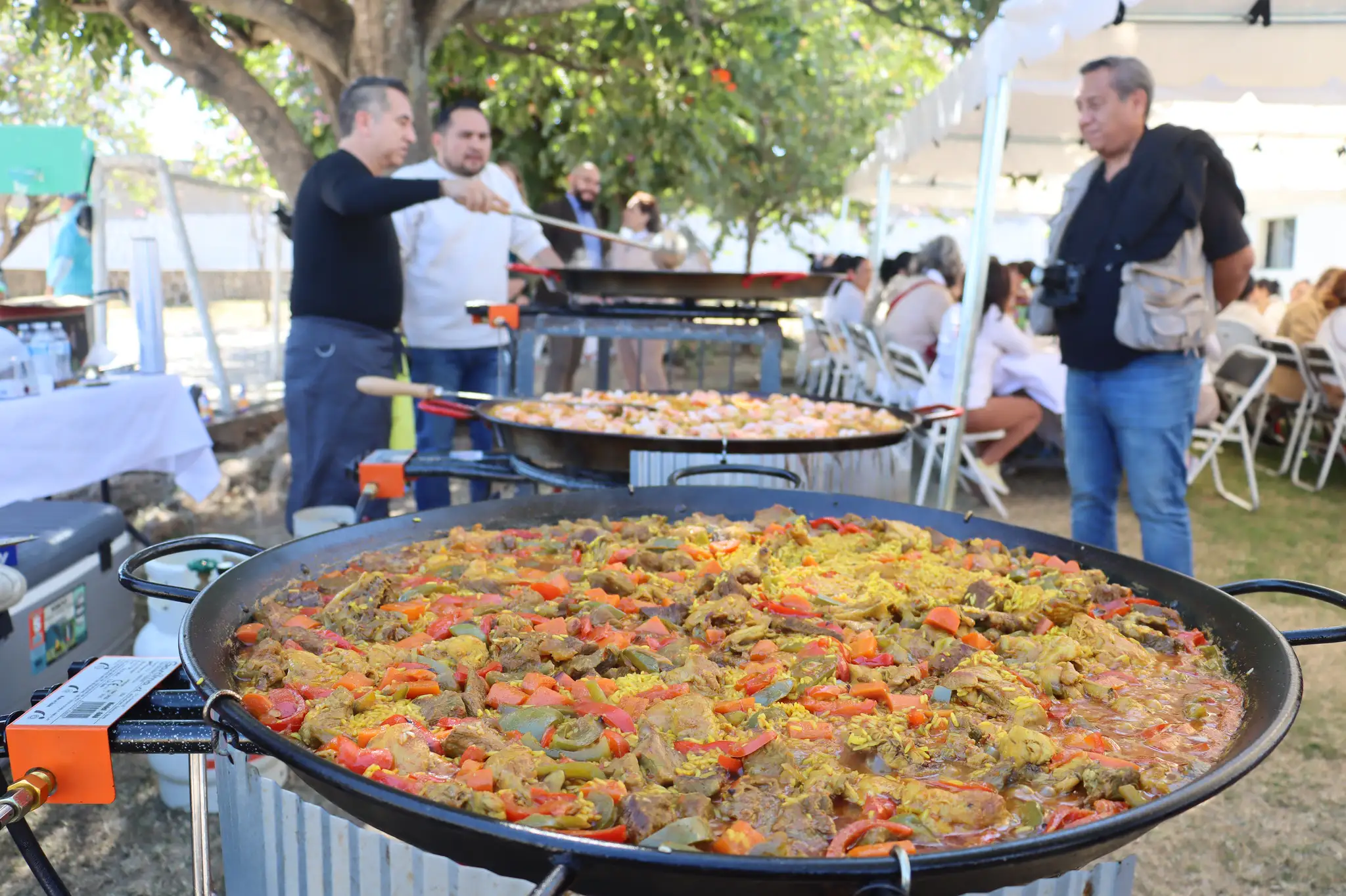 Voluntarios y representantes entregando comida en el evento del CORA con apoyo de PLA Firme.