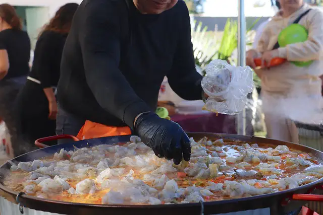 Chef preparando paella en evento social en el Centro de Reinserción Femenil con patrocinio de Grupo PLA Firme.