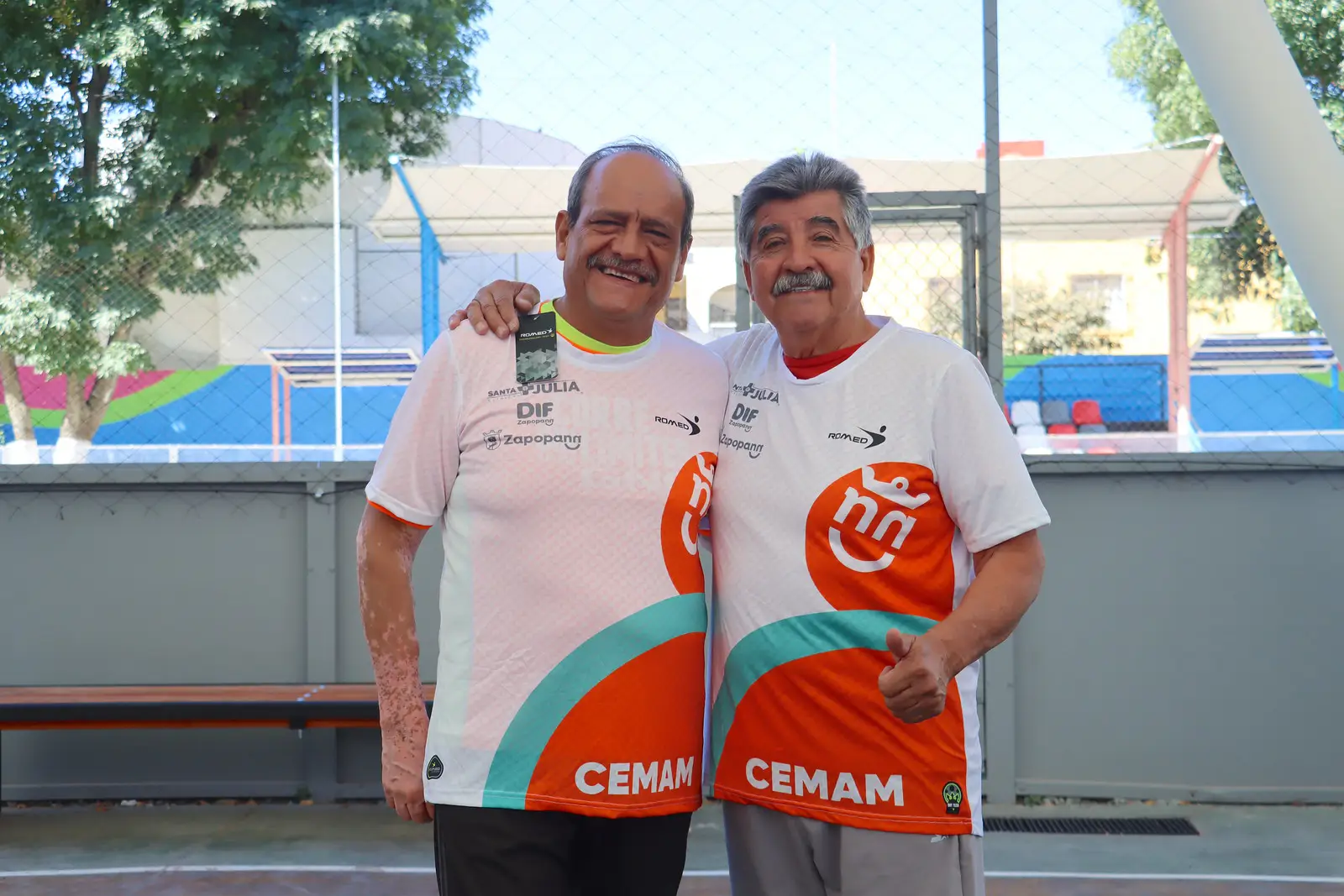 Dos jugadores del equipo de cachibol DIF Zapopan posando con los uniformes patrocinados por Grupo PLA Firme.